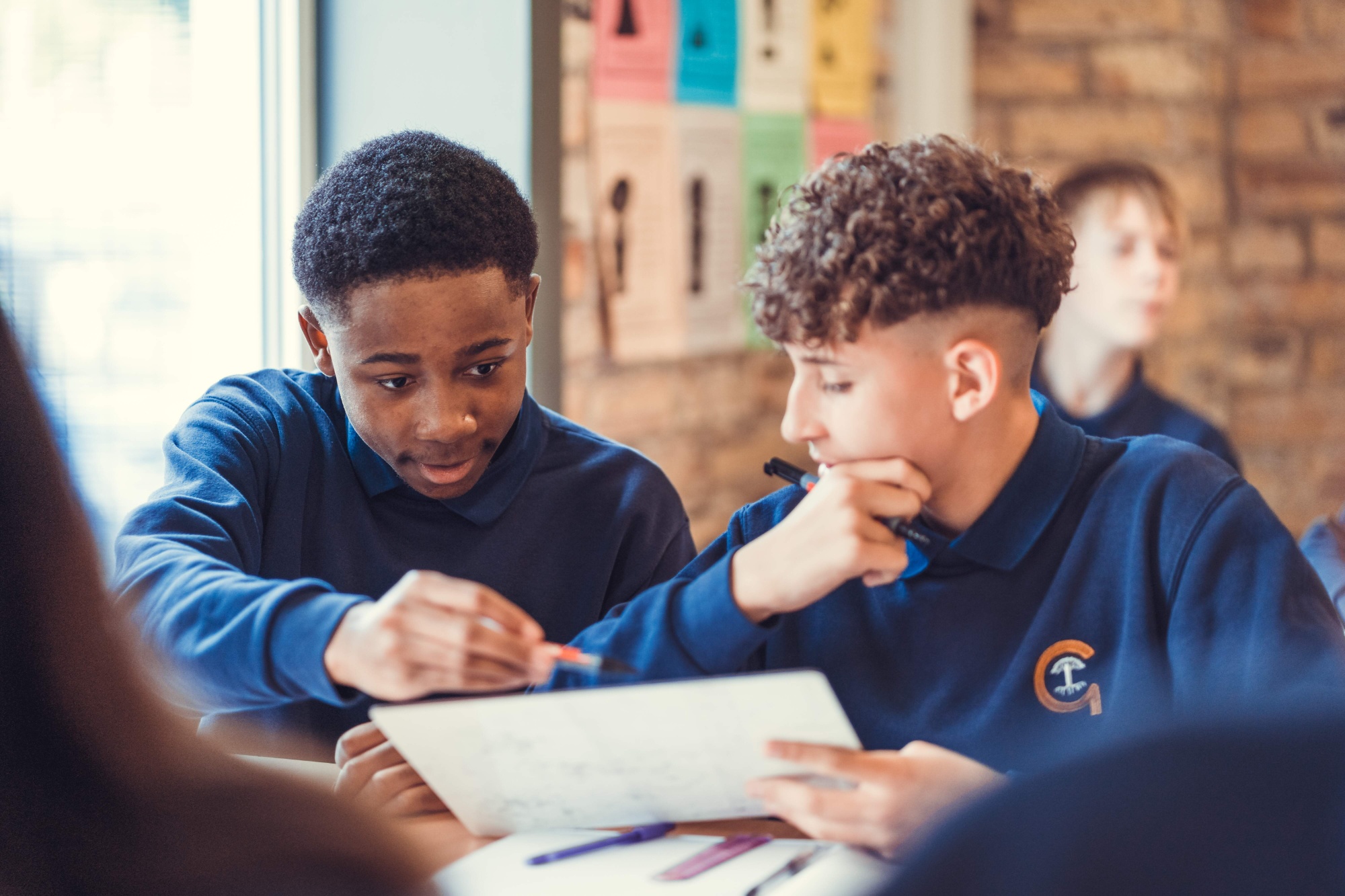 Children studying in classroom using whiteboards
