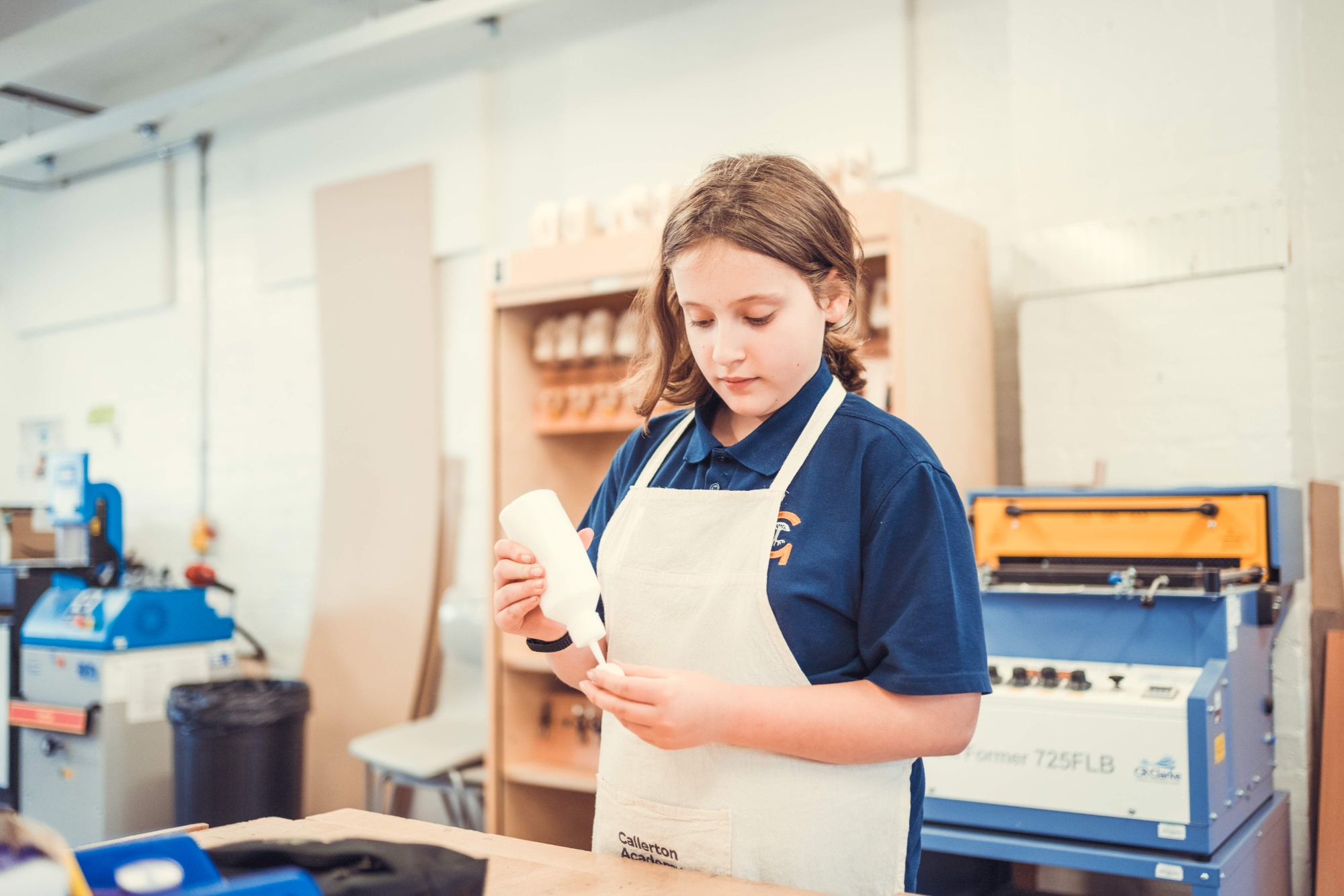 Child in workshop using the glue
